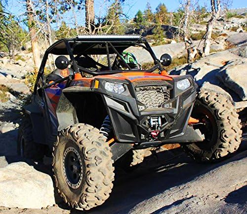 Off-road vehicle on a rocky trail with trees and mountains in the background